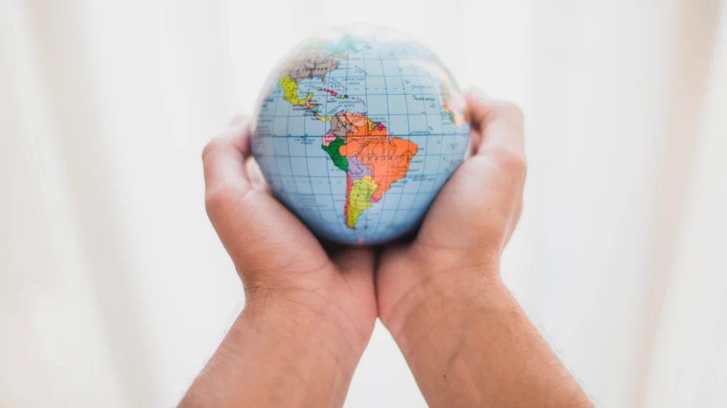 person s hand holding small globe edited scaled